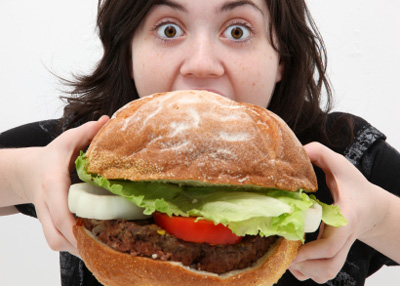 This is not a photo of me, or of a Fat Boy Burger. This is a stock photo of a woman eating a big burger. But it kind of makes the point, doesn't it?